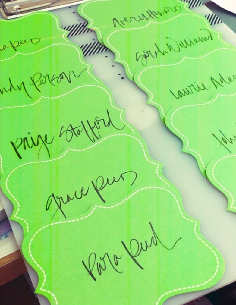 Hand-lettered guest name cards in black ink on colored paper