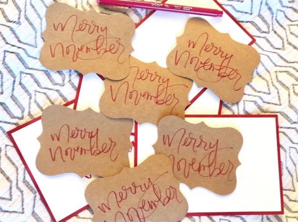Merry November hand-lettered gift tags in red ink on kraft paper